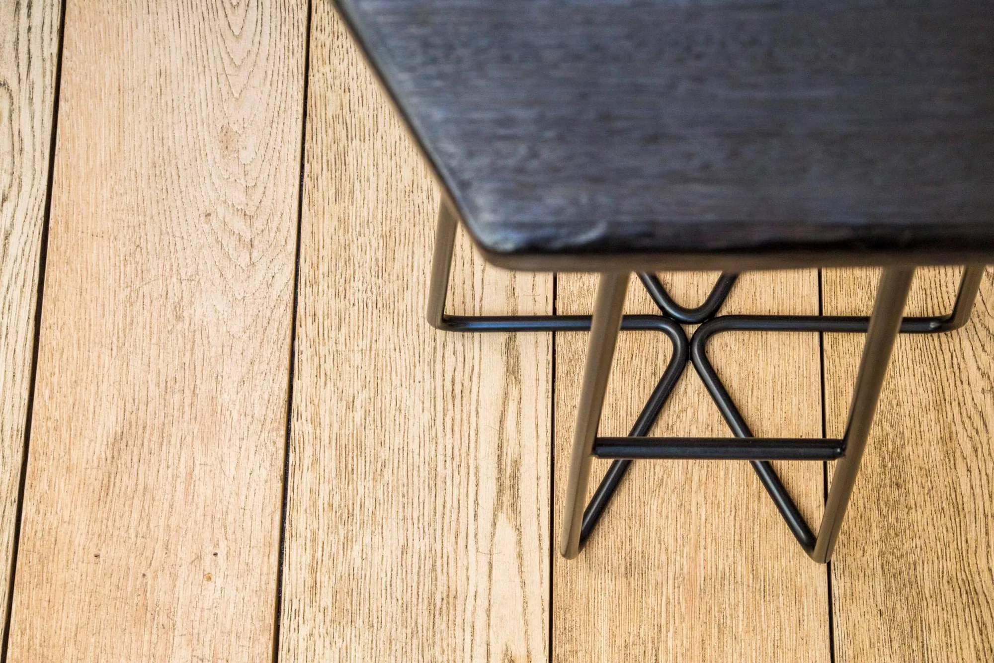 Éxi stool: top-down corner detail on oak floor.