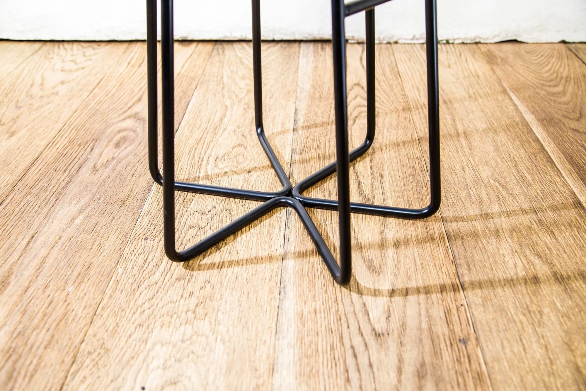 Éxi stool: base detail on oak floor.